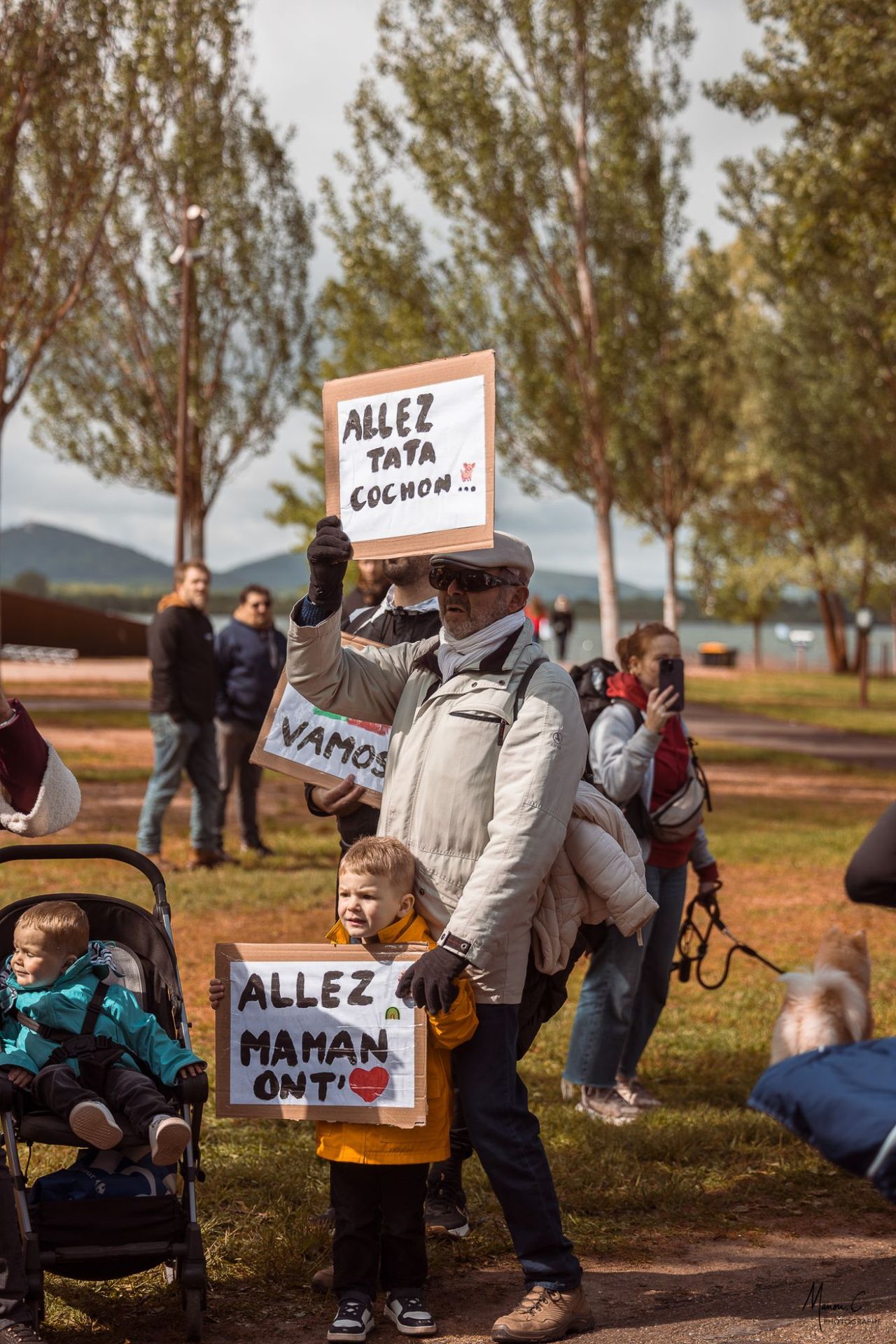 Supporters et pancartes « Allez maman » au bord du lac, 2026